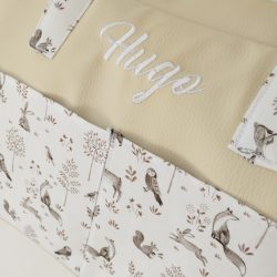 Detalle de bolso con nombre Hugo bordado, polipiel beige y tela de animalitos.